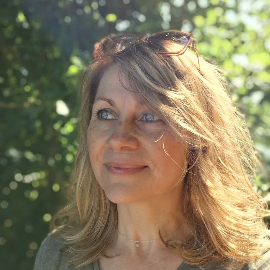 Kirsten Grella im Gegenlicht vor grünen Bäumen